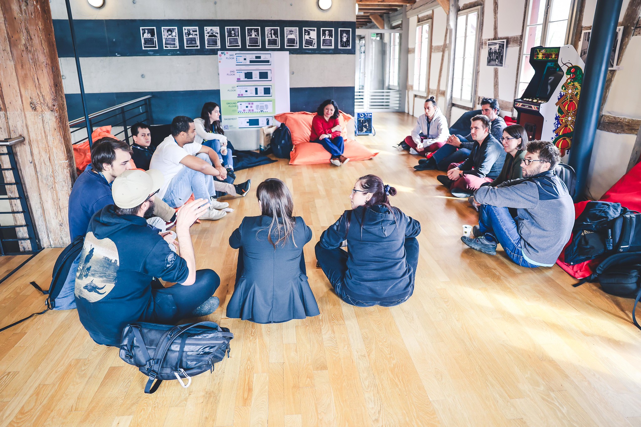 Group of people sitting in a circle on the ground for an open space session